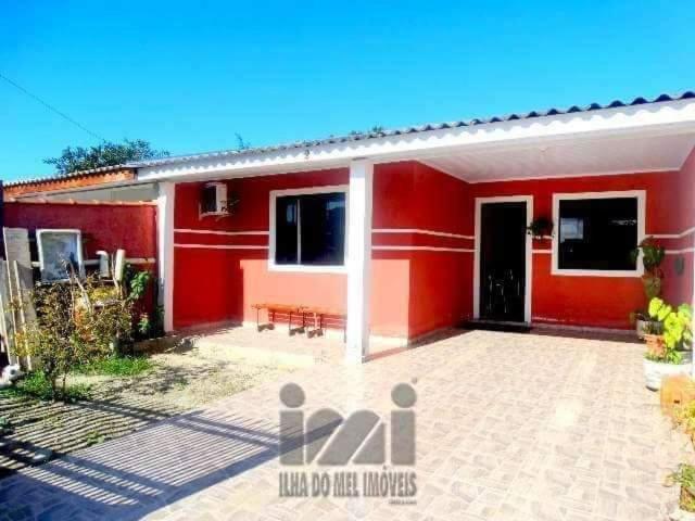 a red house with a patio in front of it at Casa 3 quartos in Pontal do Paraná