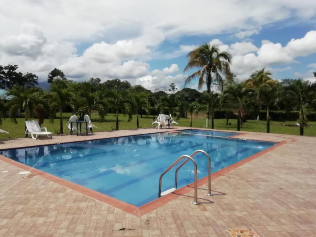 una piscina in un resort con alberi sullo sfondo di FINCA CAMPO ALEGRE a Cumaral