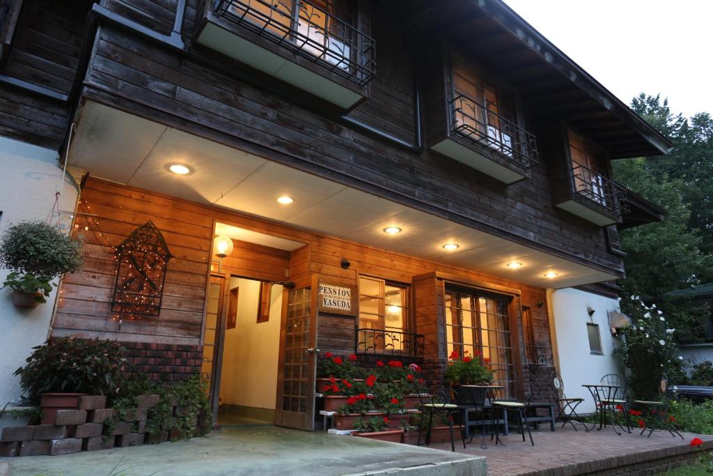 a building with a table and chairs in front of it at Pension Yasuda in Takayama