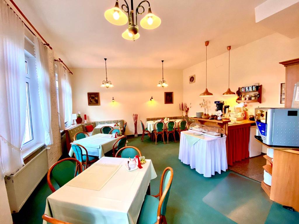 ルターシュタット・アイスレーベンにあるParkhotel Schnorrのテーブルと椅子2脚付きのレストラン、キッチンが備わるレストラン