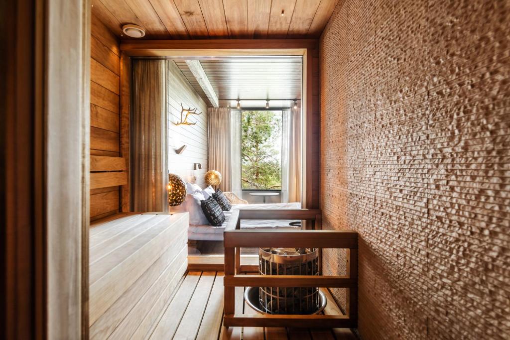 a hallway with a person sitting on a couch in a room at Lapland Hotels Sky Ounasvaara in Rovaniemi