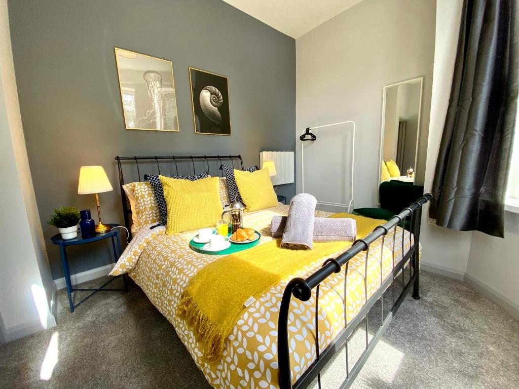 a bedroom with a bed with a yellow blanket at Trendy Stylish Apartment! - 5 Minute Walk to the Best Beach! - Great Location - Parking - Fast WiFi - Smart TV - Newly decorated - sleeps up to 6! Close to Bournemouth & Poole Town Centre & Sandbanks in Bournemouth