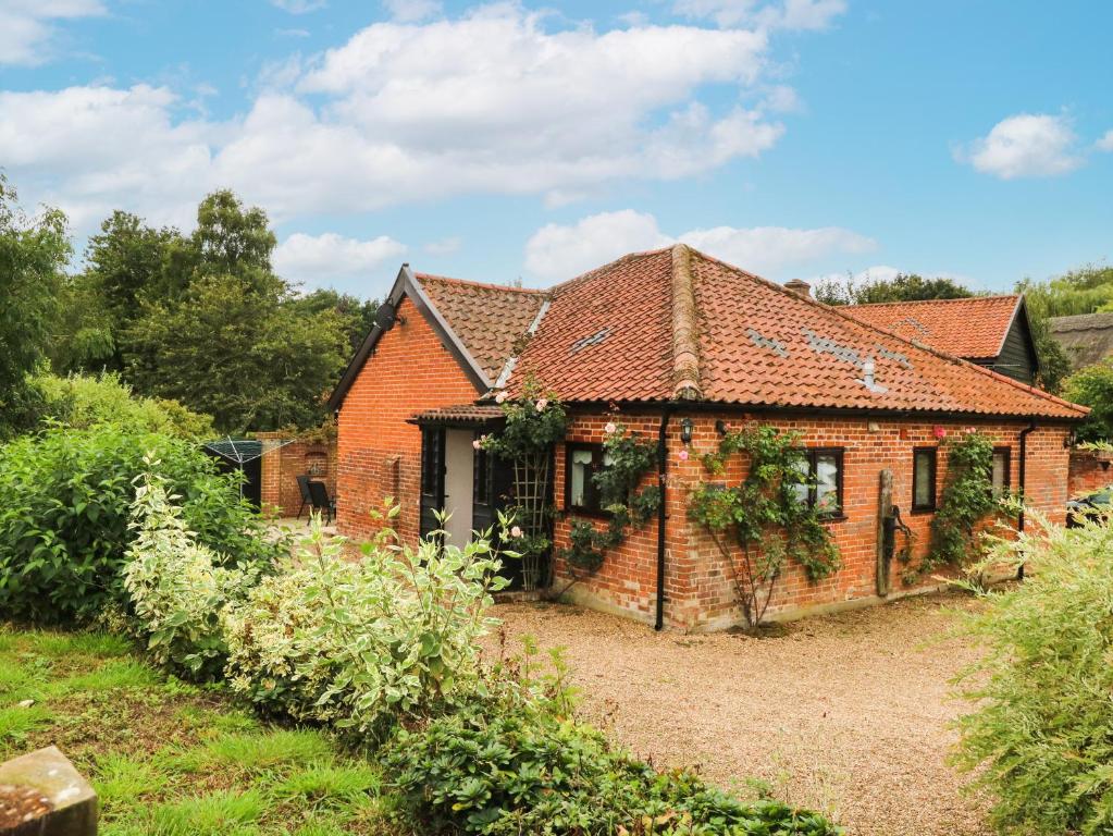 an old red brick house in a garden at Lowbrook Cottage in Diss