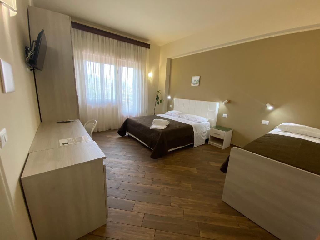 Habitación de hotel con 2 camas y TV en All’Anoneto B&B, en Catona