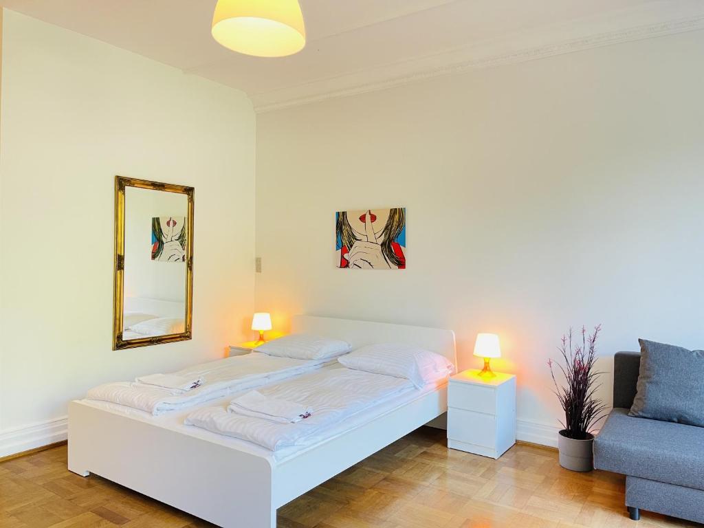 - une chambre avec un lit blanc et un canapé bleu dans l'établissement aday - Aalborg mansion - Studio with terrace and garden, à Aalborg