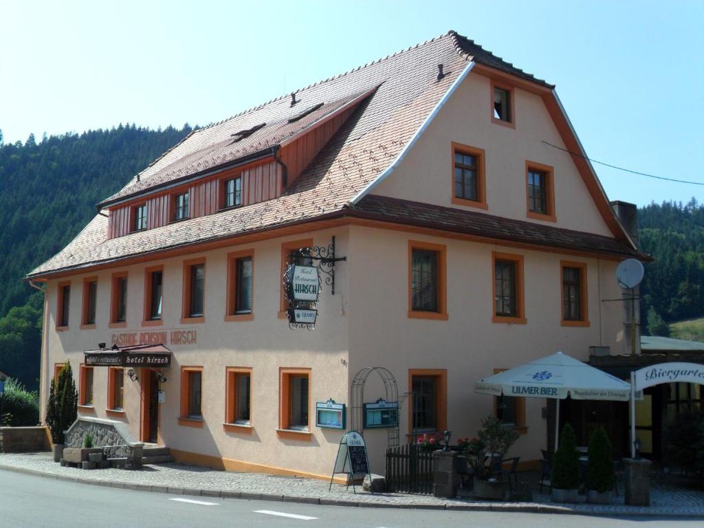 un gran edificio blanco con techo marrón en Hotel Hirsch, en Seebach
