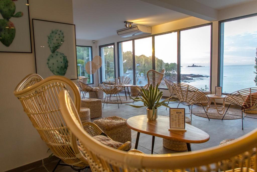 a room with chairs and a table and windows at SOWELL RESIDENCES Chênes Verts in Saint-Raphaël
