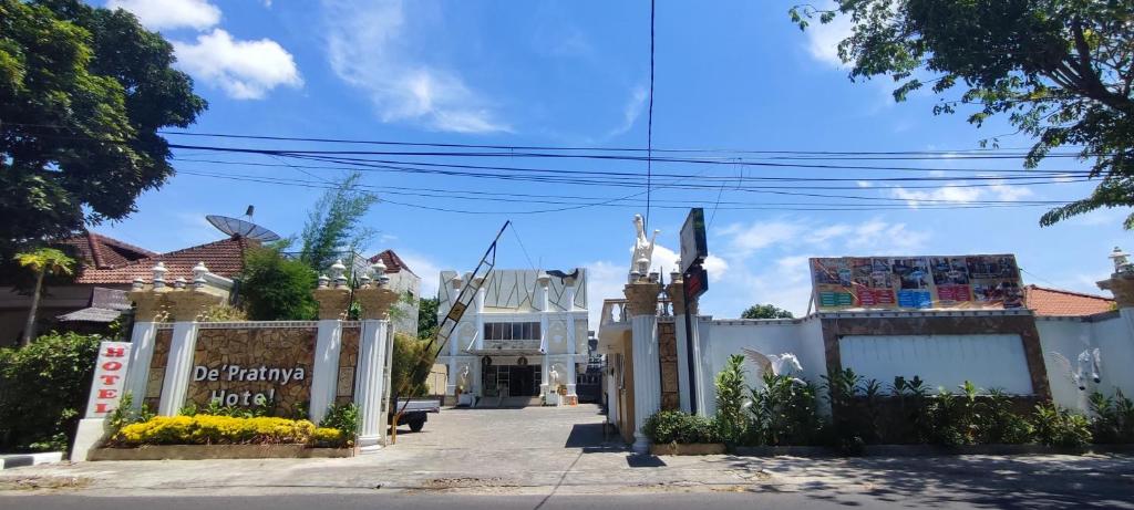 uma rua em frente a um edifício branco em Votel Hotel De'Pratnya Kediri em Kediri