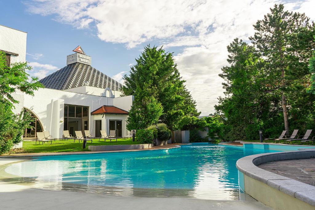 a swimming pool in front of a house at Eventhotel Pyramide in Vösendorf