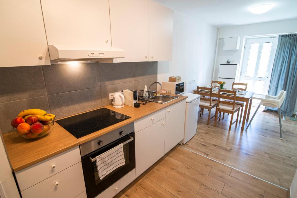 a kitchen with a bowl of fruit on the counter at Marilla Apartman in Tata