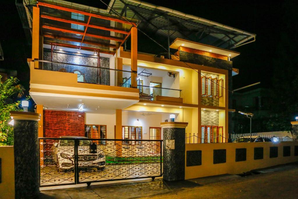 a large yellow house with a balcony at night at Belljem Homes -your own private resort -7 BHK in Trichūr