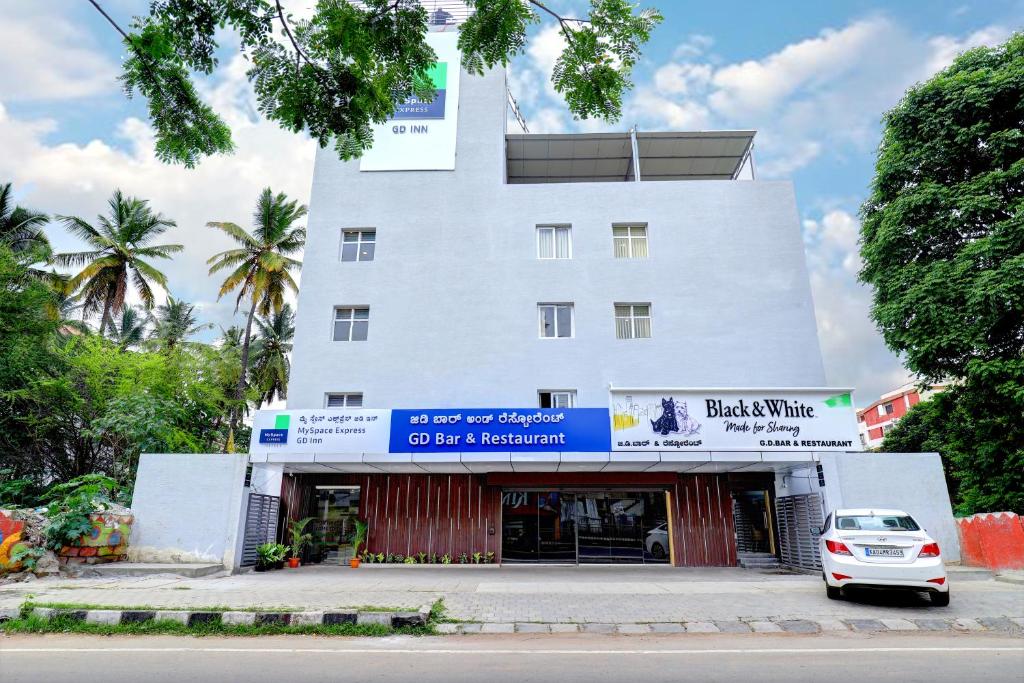 une voiture blanche garée devant un bâtiment dans l'établissement MySpace Express GD Inn, à Bangalore