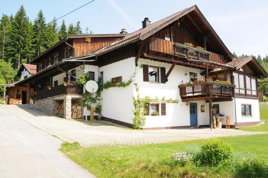ein großes weißes Haus mit Holzdach in der Unterkunft Ferienwohnungen Bredl in Zwiesel