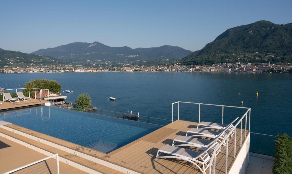 a swimming pool on the deck of a house with a lake at Ah Porticcioli Boutique Apartments in San Felice del Benaco