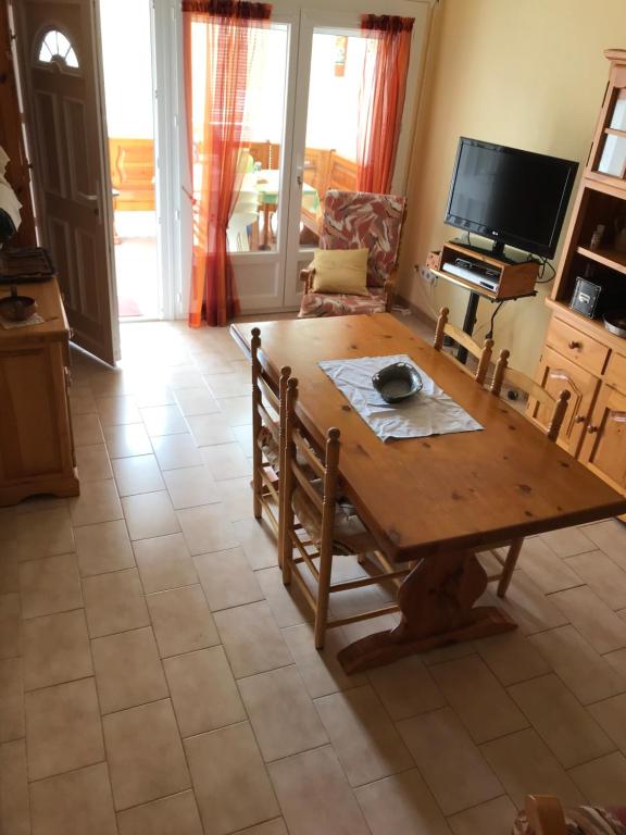 艾姆布里亞布拉瓦的住宿－charme et simplicité de ce nouveau bien，客厅配有木桌和电视。