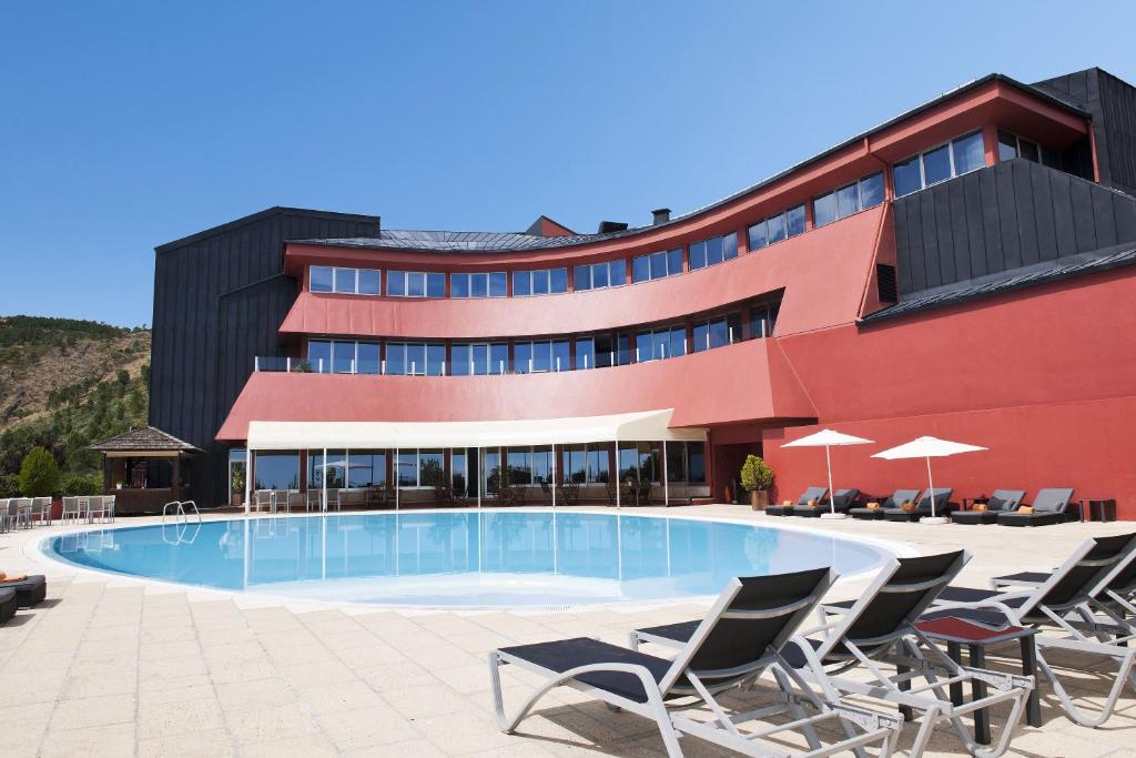 a hotel with a swimming pool in front of a building at LAM Hotel dos Carqueijais in Covilhã
