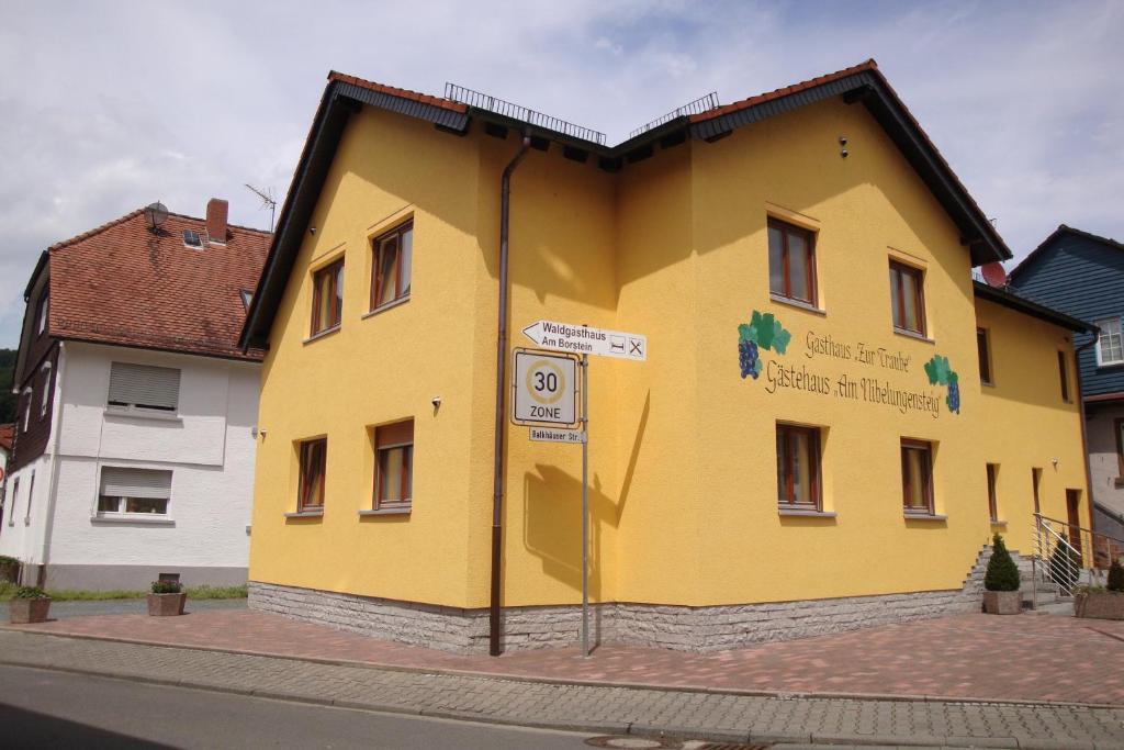 um edifício amarelo no lado de uma rua em Gaestehaeuser Am Nibelungensteig em Lautertal