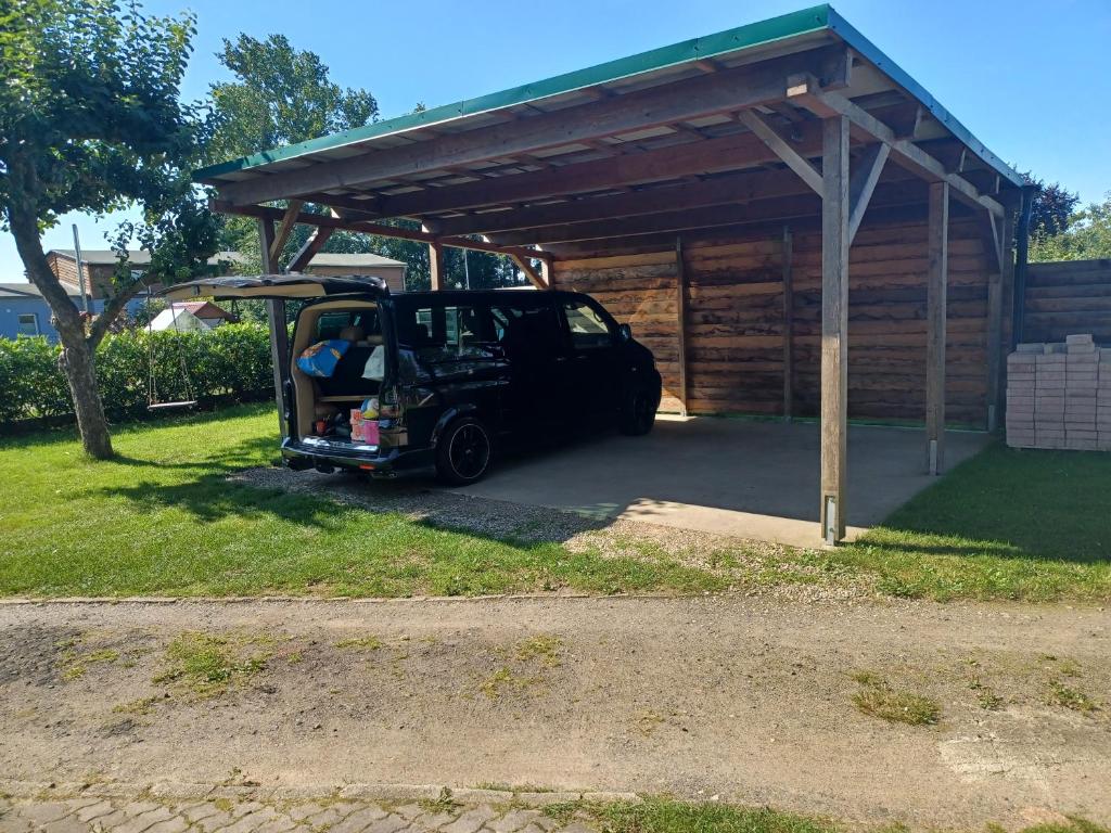 a golf cart is parked under a shed at FeWo s Runde Wiese RW in Greifswald