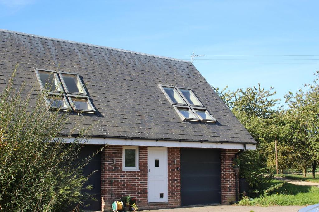 una casa in mattoni con tre finestre e un garage di Cherry Trees a Stowmarket