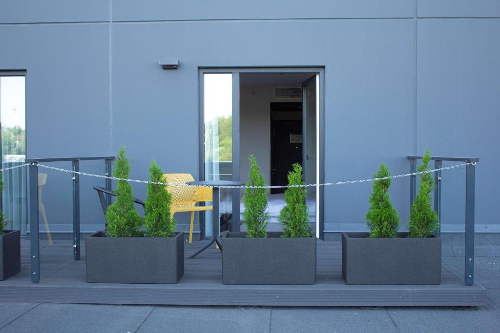a group of plants in pots in front of a building at Park Inn by Radisson Vilnius Airport Hotel & Conference Centre in Vilnius