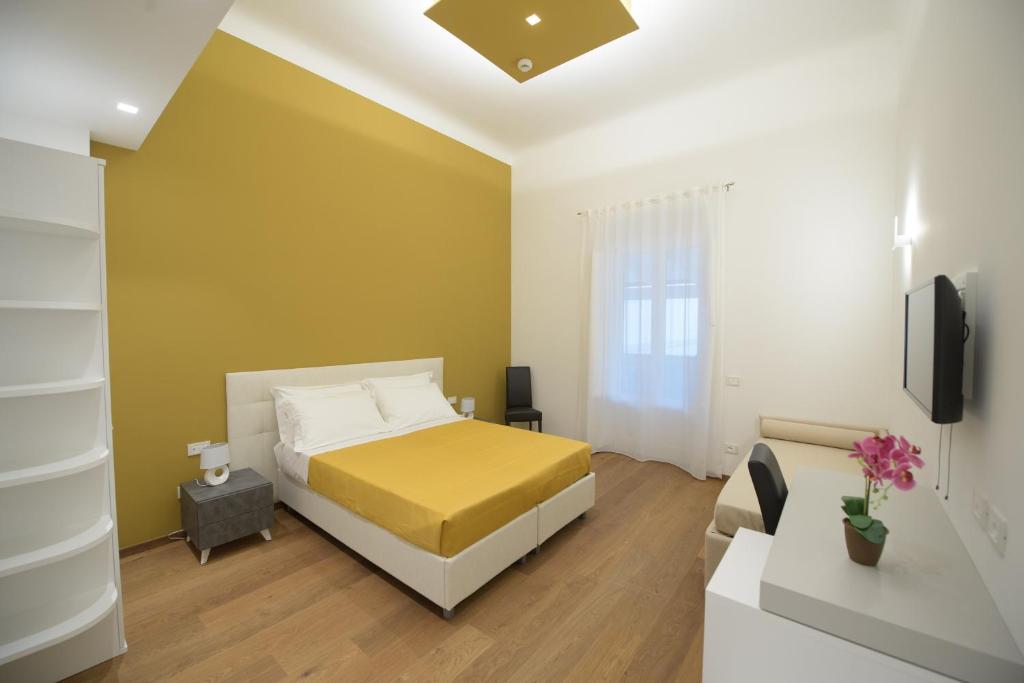een slaapkamer met een bed en een tv in een kamer bij "Corte Mopps" città della ceramica Grottaglie - SPA Elysium in Grottaglie