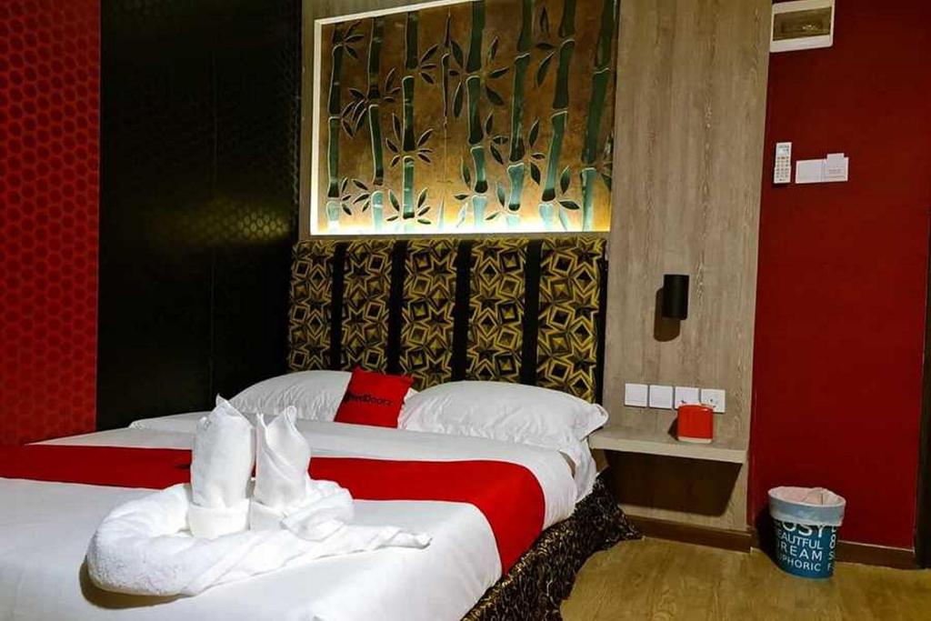 - une chambre d'hôtel avec 2 lits et des serviettes blanches dans l'établissement RedDoorz Plus near Nagoya Hill Batam 6, à Bumiayu