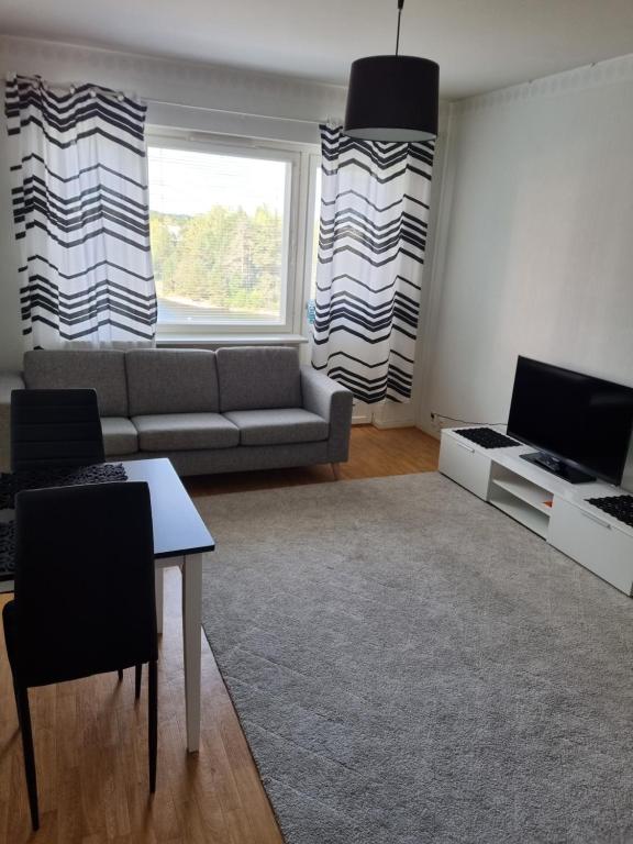 uma sala de estar com um sofá e uma mesa em Studio at Koulukatu em Savonlinna