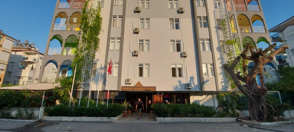 um grande edifício com uma pessoa de pé na frente dele em Tunali Apart Hotel em Antalya