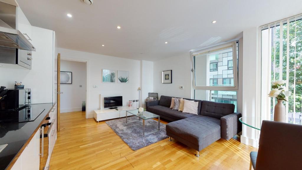 a living room with a couch and a table at Spacious Serviced Apartments Canary Wharf in London
