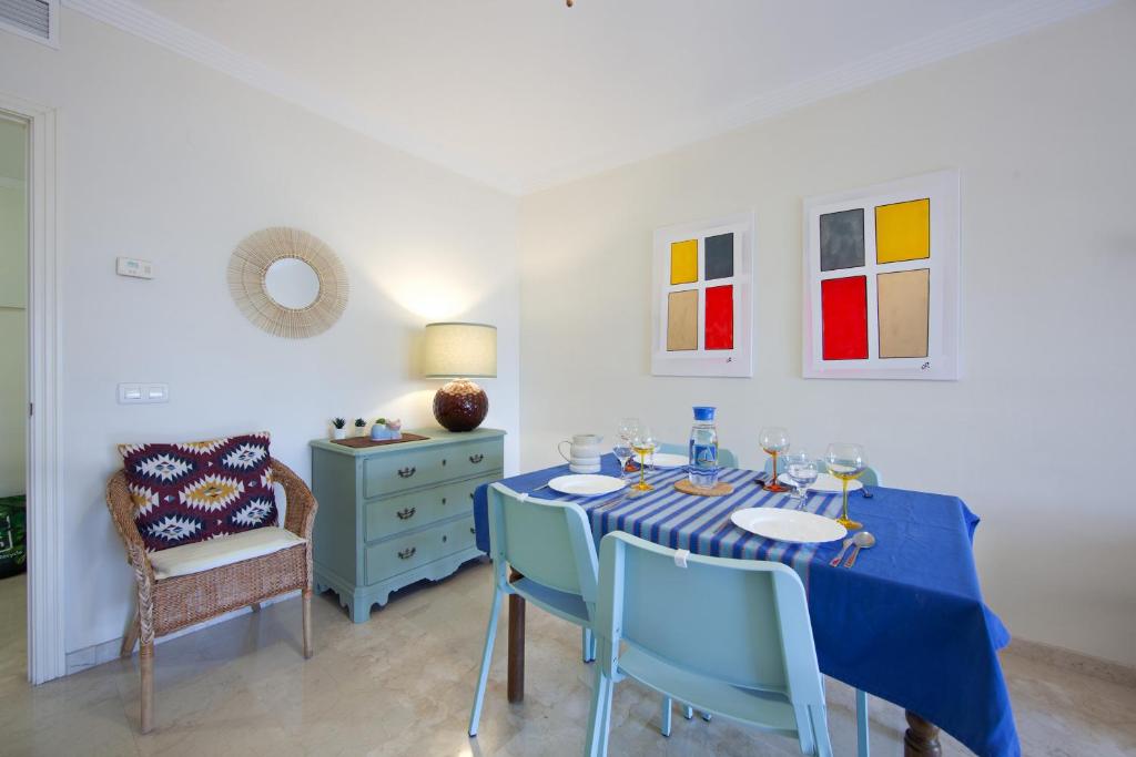 una sala da pranzo con tavolo e sedie blu di Pinogolf de Don Carlos a Marbella