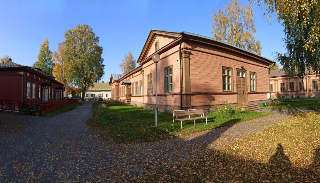 uma casa de madeira com um banco em frente em Huoneistohotelli Marja em Mikkeli