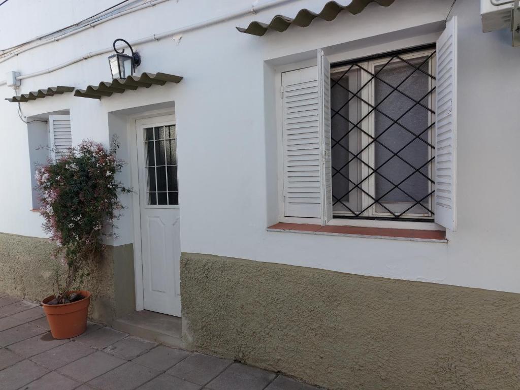 a white house with a window and a potted plant at Departamento centro salta in Salta