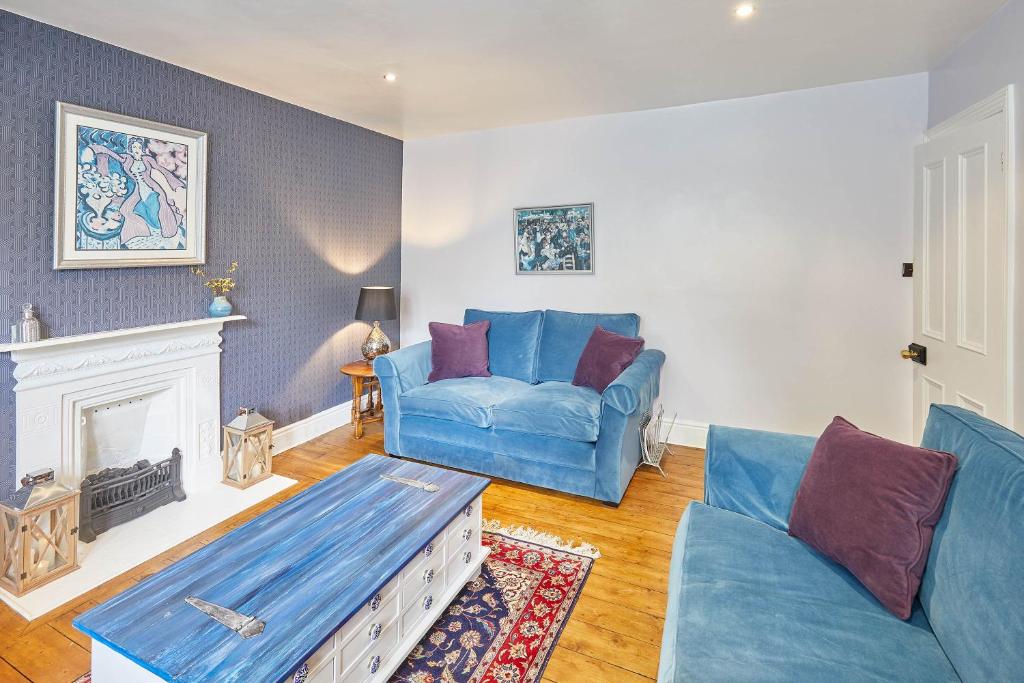 salon z niebieską kanapą i kominkiem w obiekcie Host & Stay - Kulla Loft w mieście Harrogate