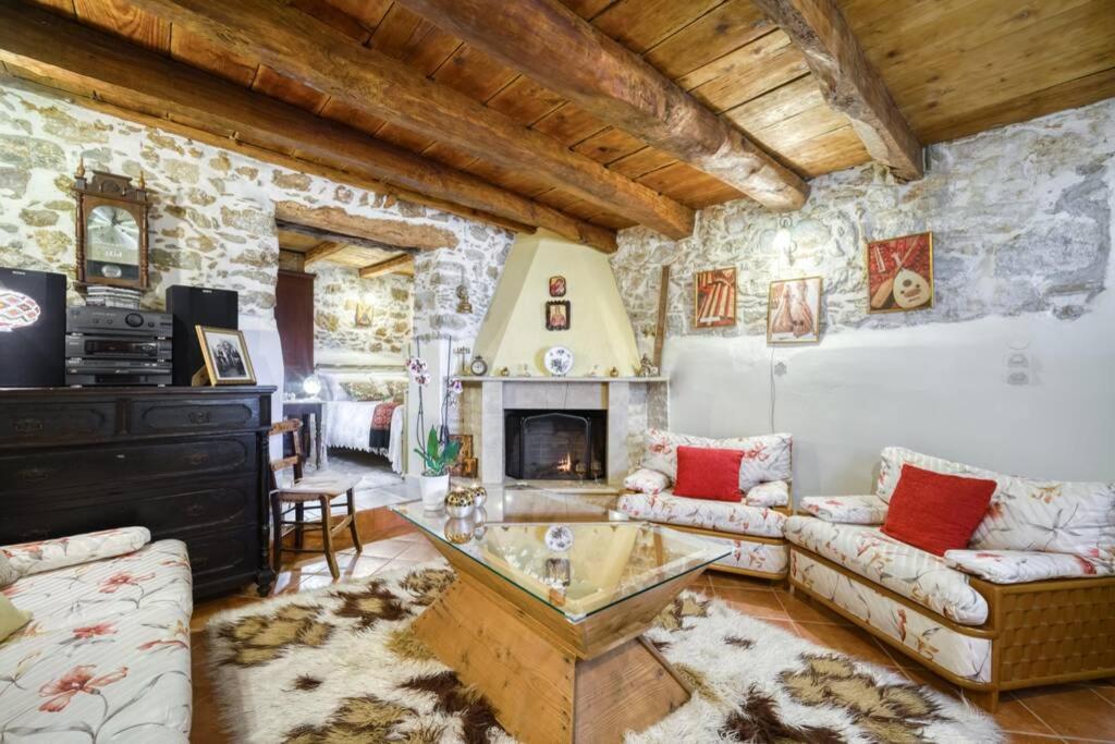 a living room with a couch and a fireplace at Traditional Cretan Stone House in the Center of Crete in Xidhás