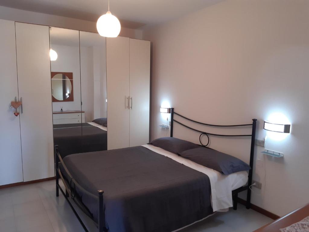 a bedroom with a large bed and a mirror at Appartamento La Libellula in Grosseto