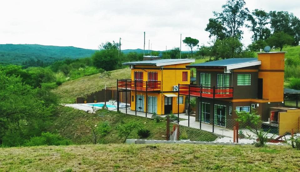 una casa amarilla en la cima de una colina en Balcones de Molinari en Cosquín