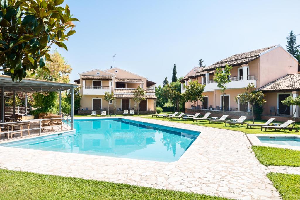a swimming pool in the backyard of a house at Folies Corfu Town Hotel Apartments in Corfu