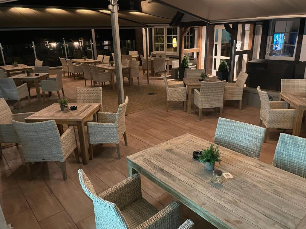 um restaurante vazio com mesas e cadeiras de madeira em Dötlinger Hof em Dötlingen