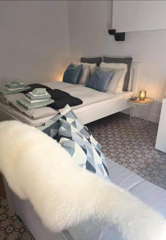 a bedroom with a white bed with blue pillows at La cave de Nana in Liège