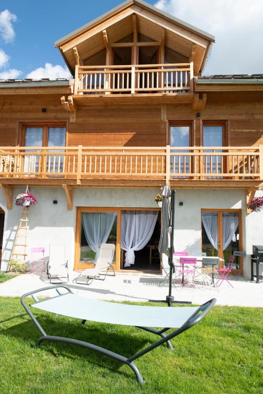 une maison avec un balcon, une table et des chaises dans l'établissement LE CHALET BAZAN, à Arvieux