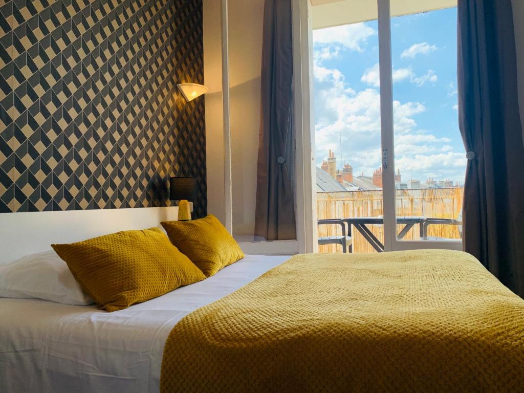 1 dormitorio con cama y ventana grande en Hôtel Trianon Tours, en Tours