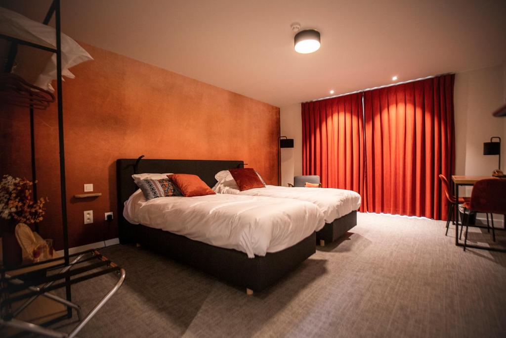 a bedroom with a bed and a red curtain at Hotel - B&B Elementum in Kortrijk
