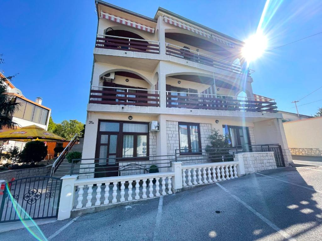 a large white building with a white fence in front of it at Apartmani Selina in Jadranovo
