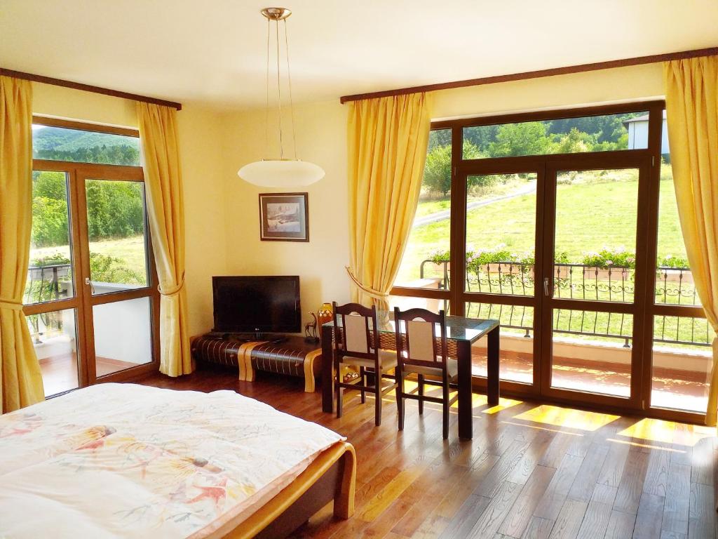a bedroom with a bed and a table and chairs at Стаи за Гости Lavender Lozen in Lozen