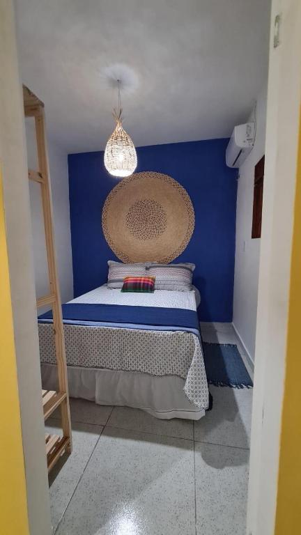 Schlafzimmer mit einem Bett mit blauer Wand in der Unterkunft Formosinha in Baía Formosa