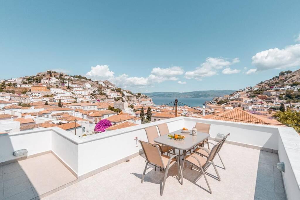 balcón con mesa, sillas y vistas en Villa Maria - Hydra Dream Houses en Hydra