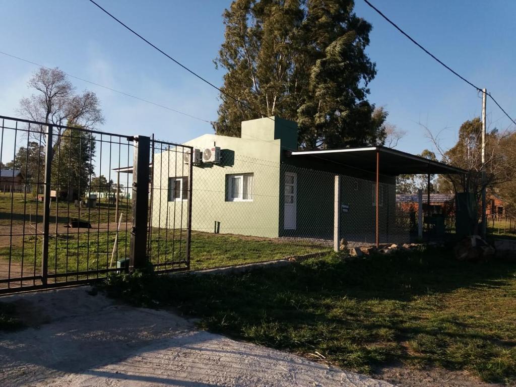 una puerta frente a un edificio en un campo en Deptos del sur en Tandil