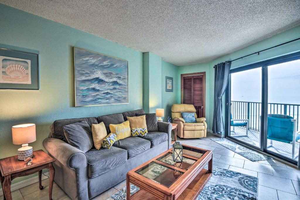 Ocean-View Condo with Balcony on Daytona Beach! في Daytona Beach Shores: غرفة معيشة مع أريكة وشرفة