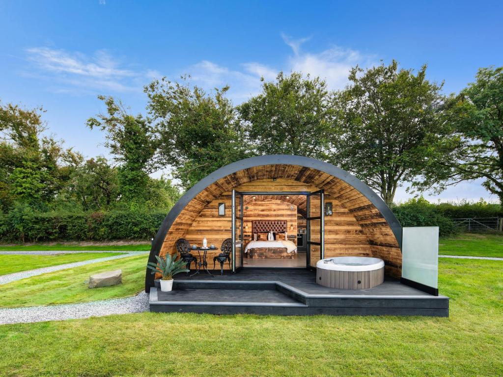 a bedroom in a garden with an archway at The Piglet Pod in Llanarth