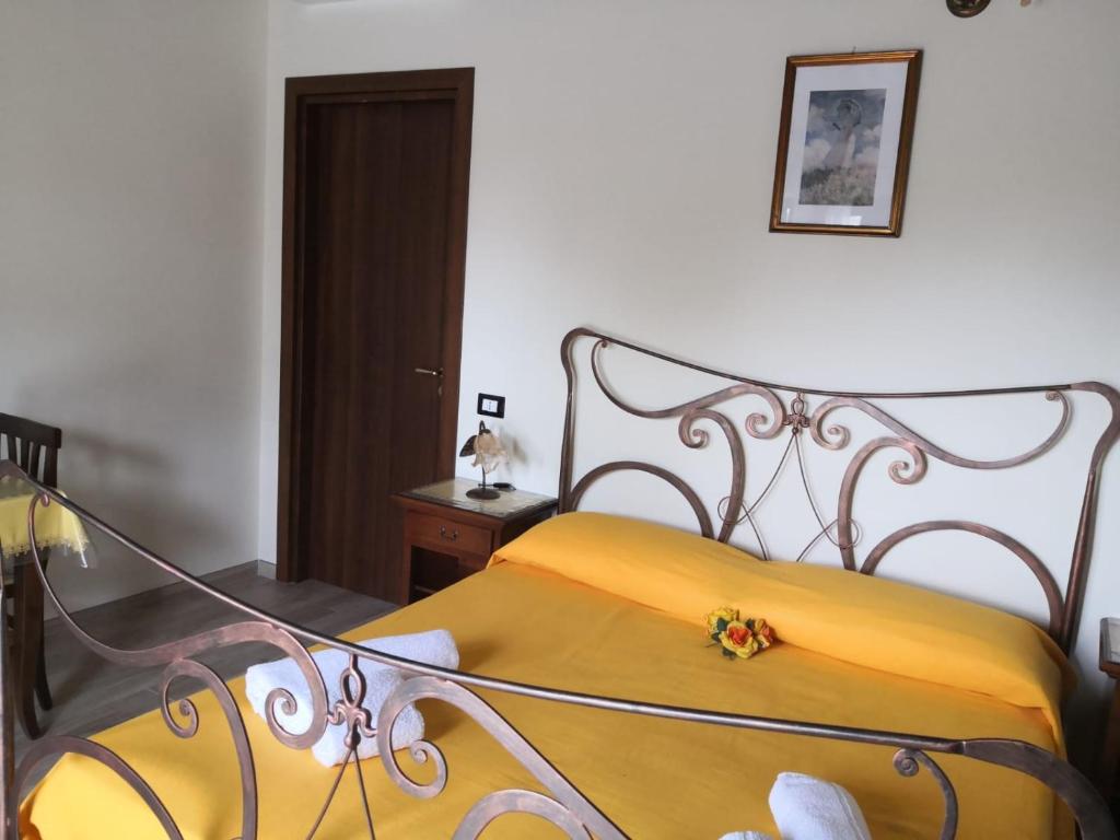 - une chambre avec un lit et une couverture jaune dans l'établissement Camera matrimoniale 1 per vacanza al mare VILLA FRANCA, à Cariati